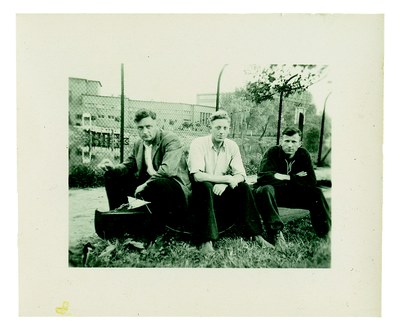 Auf einem Paddelboot sitzen (v.l.n.r.) die "Brenner" Karl Pötzinger, Johann Niemann und Siegfried Graetschuss am Zaun der "T4"-Anstalt Brandenburg. Sommer 1940. Niemann notierte "Brandenburg" unter dem Foto